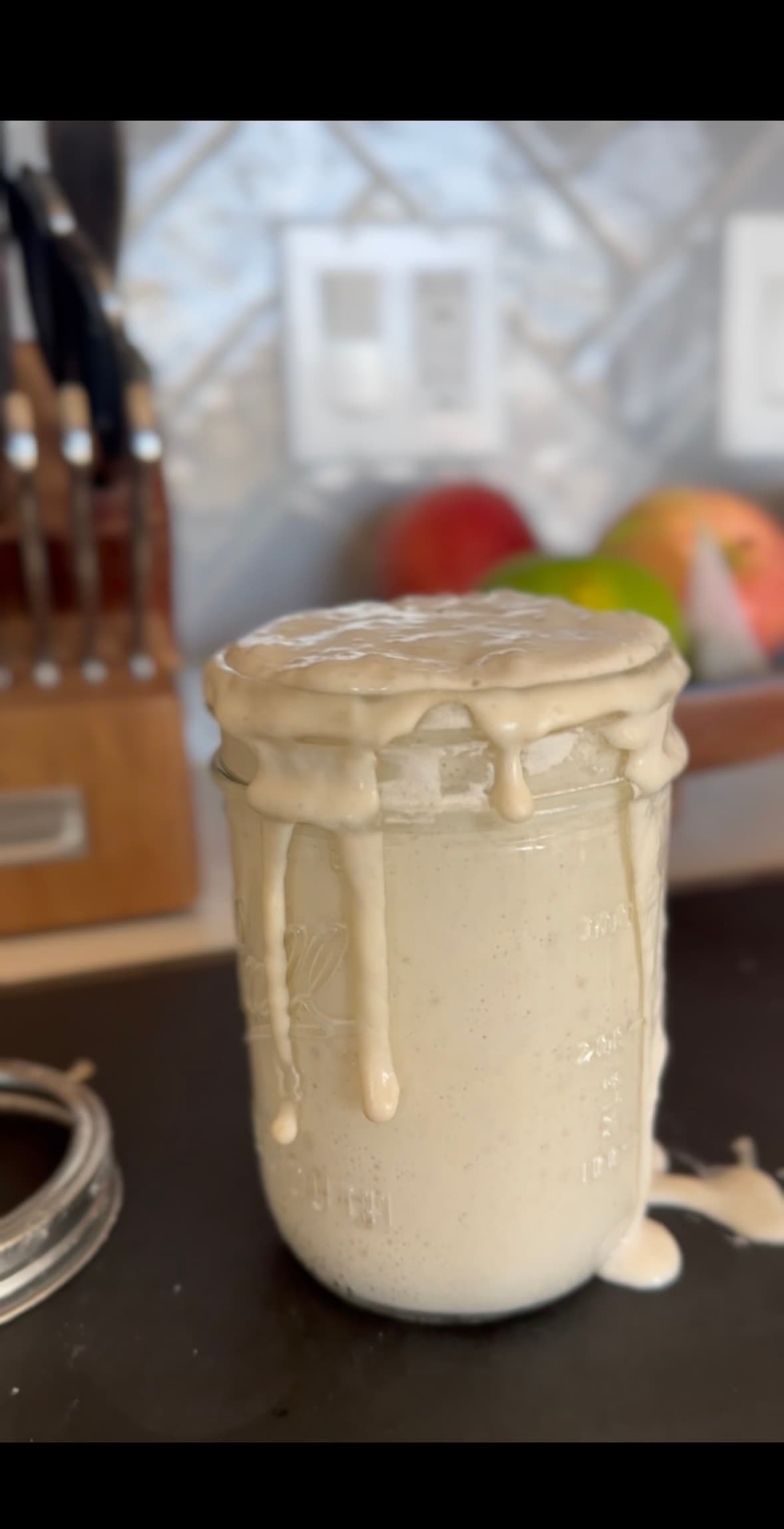 An active sourdough starter bubbling over the top of its jar